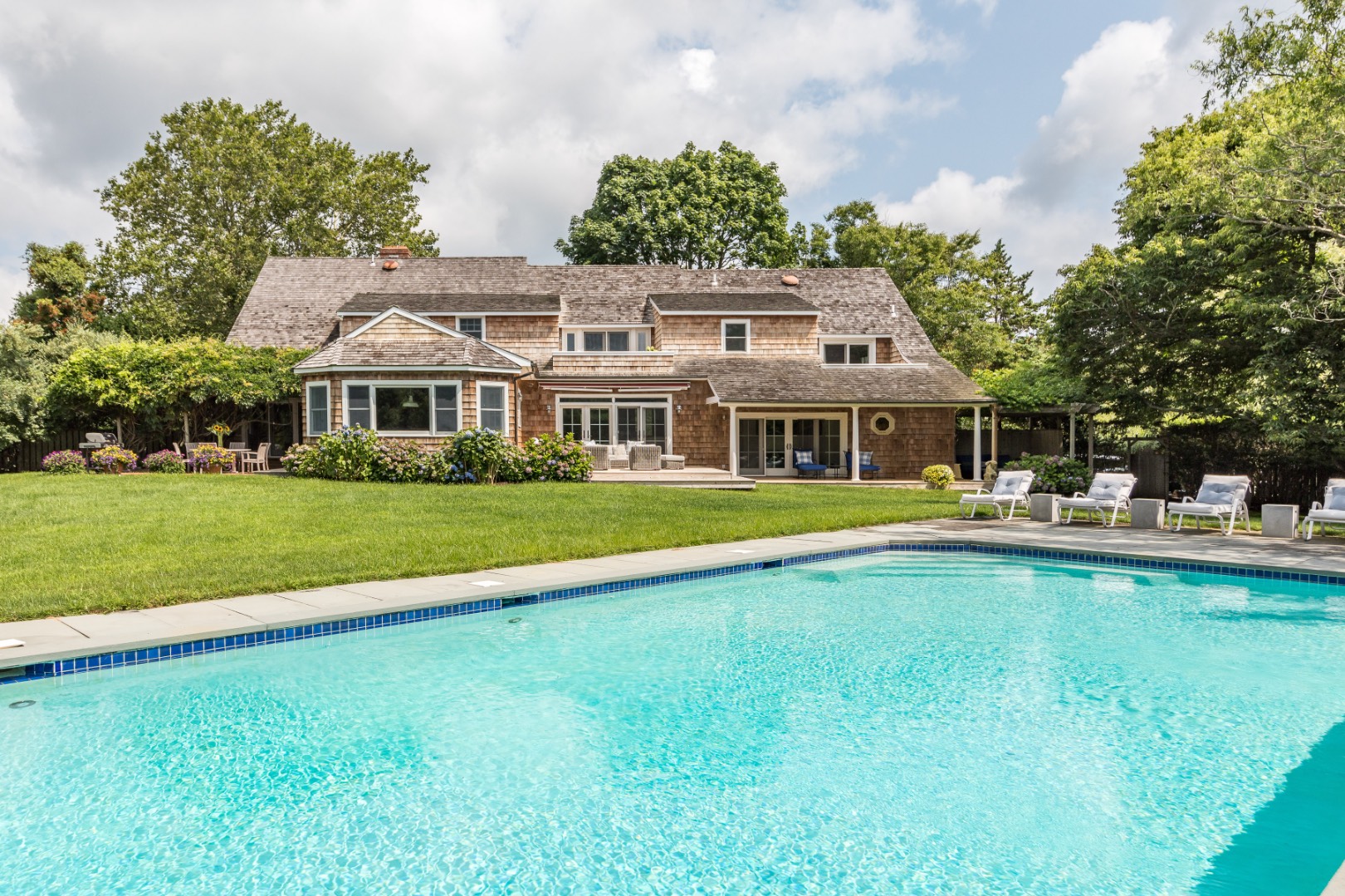 227 Sagaponack Road Bridgehampton, NY 11932 - Photo 8 of 26 a front view of a house with swimming pool having outdoor seating