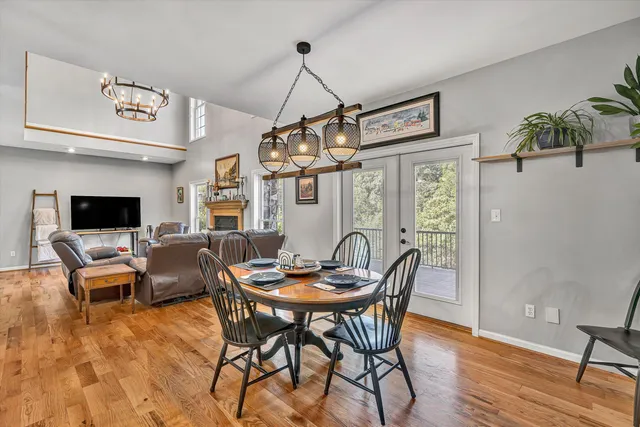 a dining room with furniture a chandelier and wooden floor