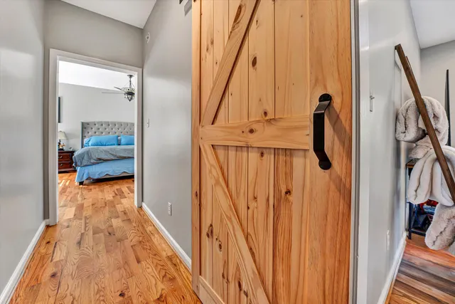 a view of a hallway with wooden floor and staircase