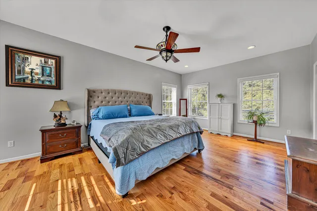 a spacious bedroom with a bed and wooden floor