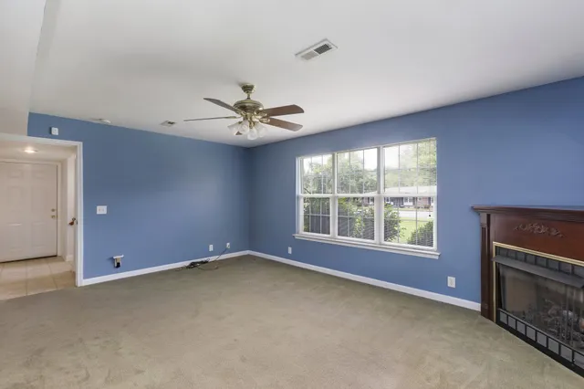 an empty room with a fireplace and windows
