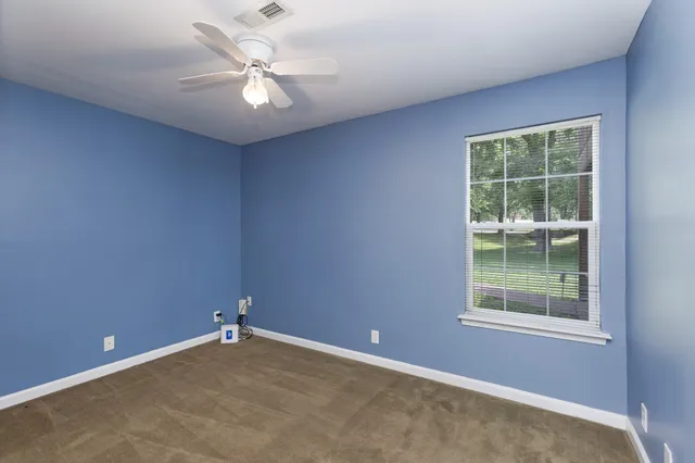 an empty room with a window and a fan