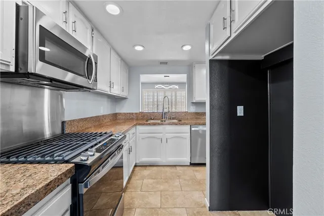 a kitchen with stainless steel appliances granite countertop a stove and a microwave