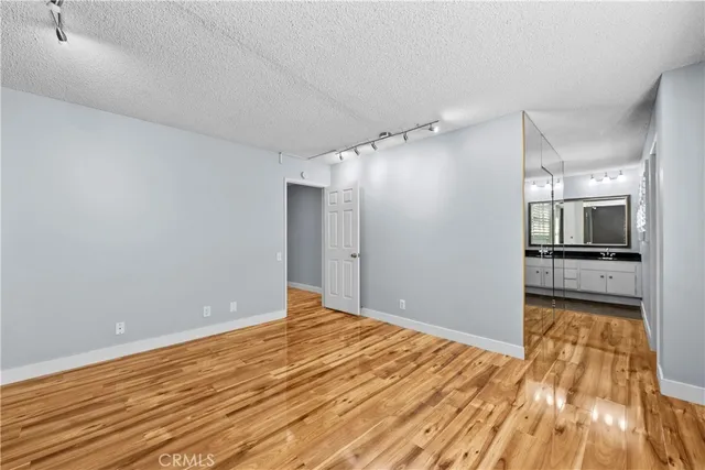 a view of a big room with wooden floor and a kitchen