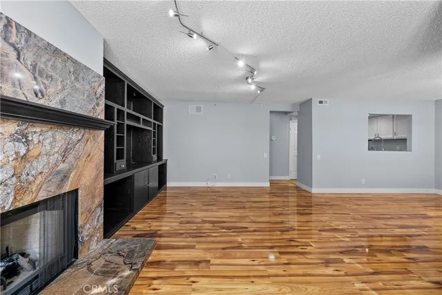a view of empty room with wooden floor and fireplace