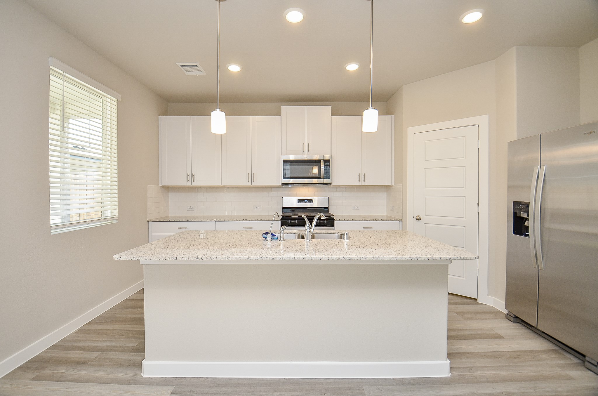 3107 Boulder Rnch Drive Houston, TX 77063 - Photo 17 of 40 a large kitchen with kitchen island white cabinets and stainless steel appliances