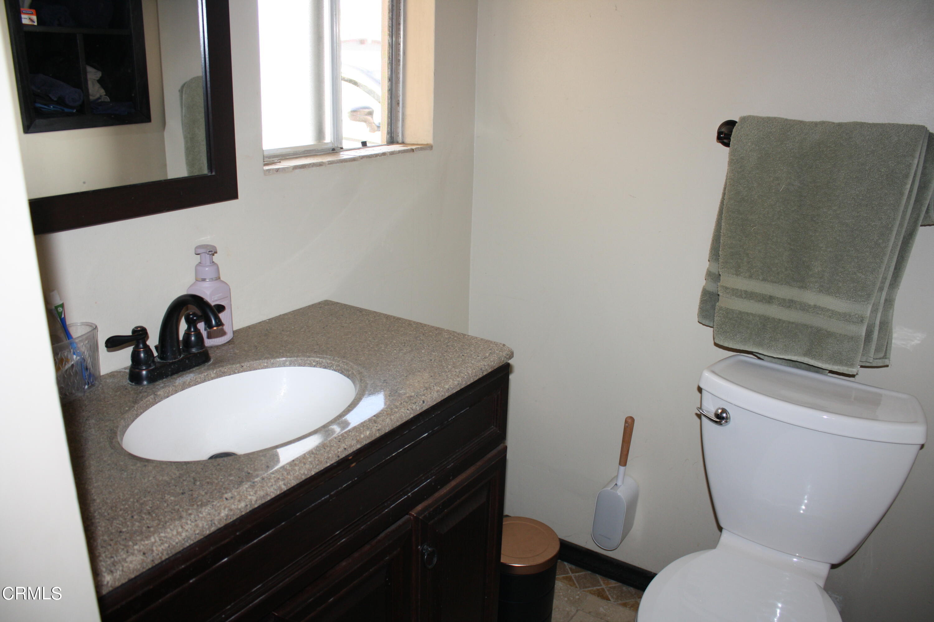 3500 Madera Place Oxnard, CA 93033 - Photo 7 of 9 a bathroom with a granite countertop toilet sink and mirror