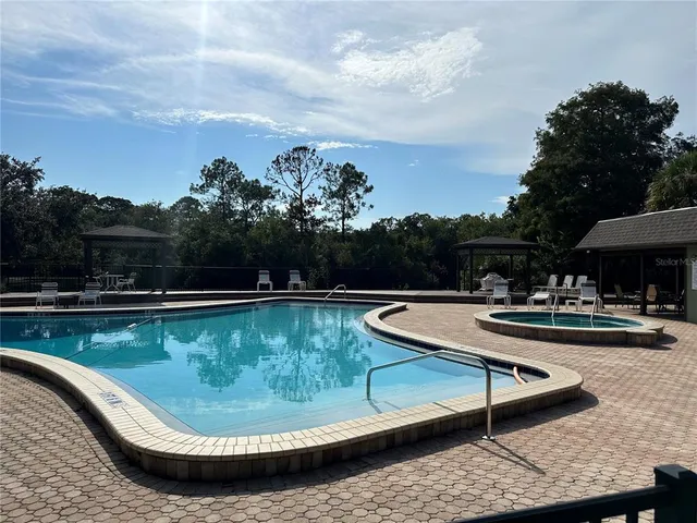 a view of a swimming pool with a chair and tables