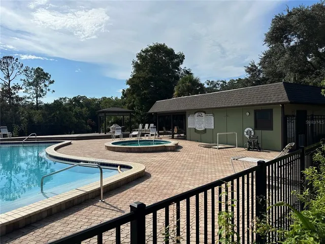 a view of a house with pool and chairs