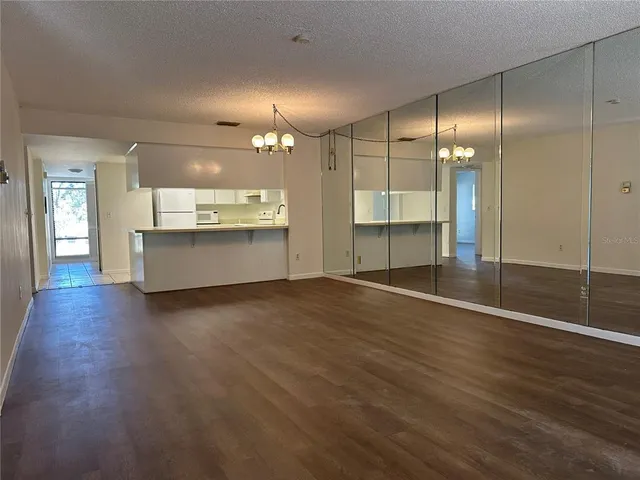 an empty room with wooden floor and bathroom view