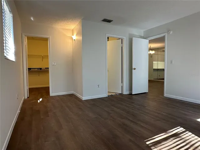 a view of an empty room with closet and a window