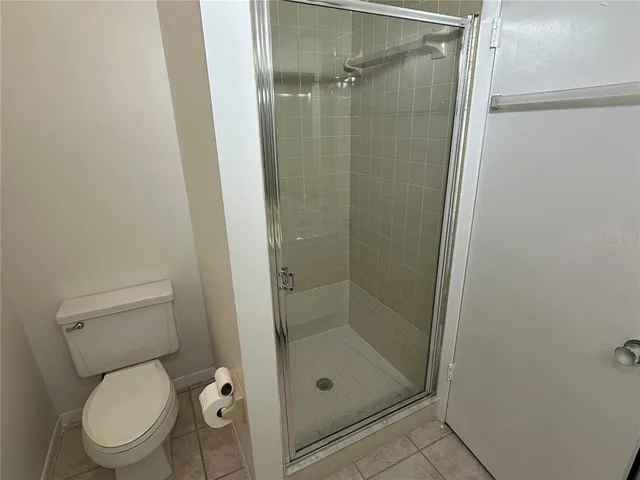 a white toilet next to a bathroom