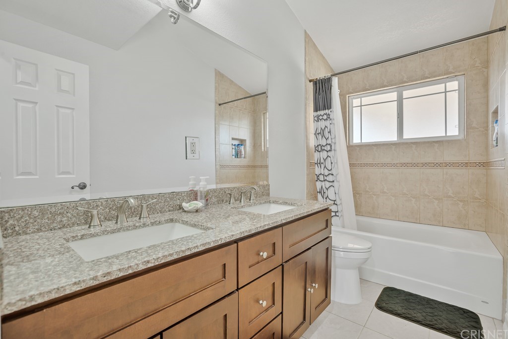20610 Gresham Street Winnetka, CA 91306 - Photo 15 of 33 a bathroom with a granite countertop sink a toilet and bathtub