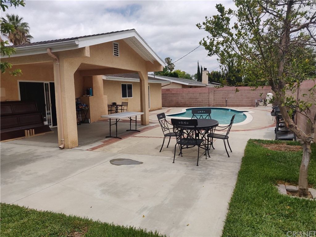 20610 Gresham Street Winnetka, CA 91306 - Photo 24 of 33 a view of a patio with table and chairs potted plants and a large tree