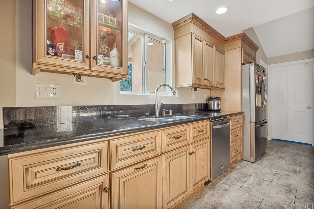 20610 Gresham Street Winnetka, CA 91306 - Photo 10 of 33 a kitchen with granite countertop a sink stainless steel appliances and cabinets