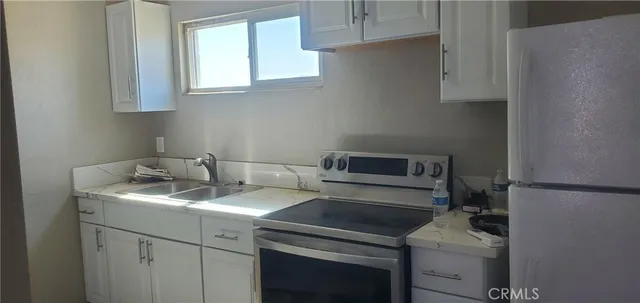 a kitchen with a sink stove and cabinets