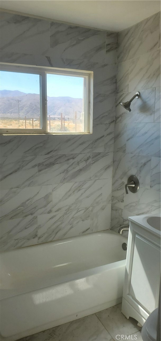 7634 Cinnabar Road Mojave, CA 93501 - Photo 8 of 8 a bathroom with a bathtub and window