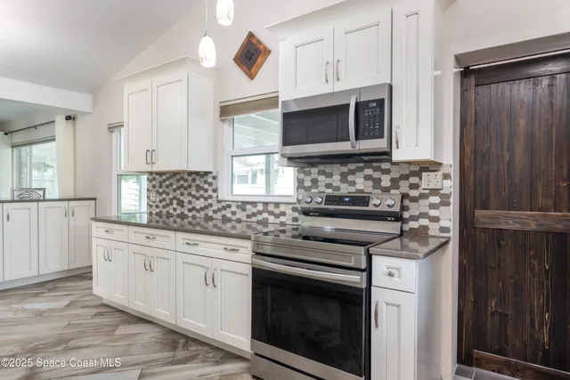a kitchen with stainless steel appliances granite countertop a stove microwave and cabinets