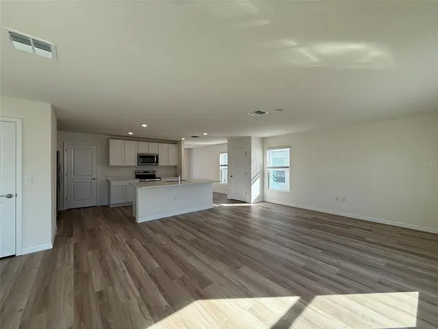 a view of kitchen and hall with wooden floor