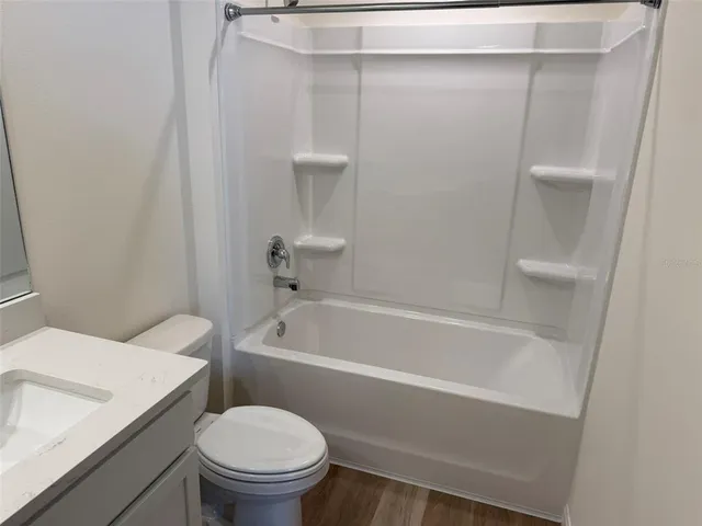 a white toilet sitting next to a bath tub