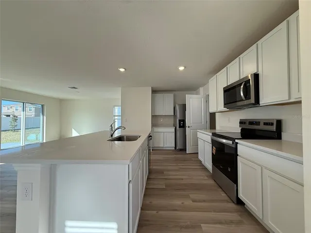 a kitchen with stainless steel appliances granite countertop a sink and dishwasher a stove top oven with wooden floor