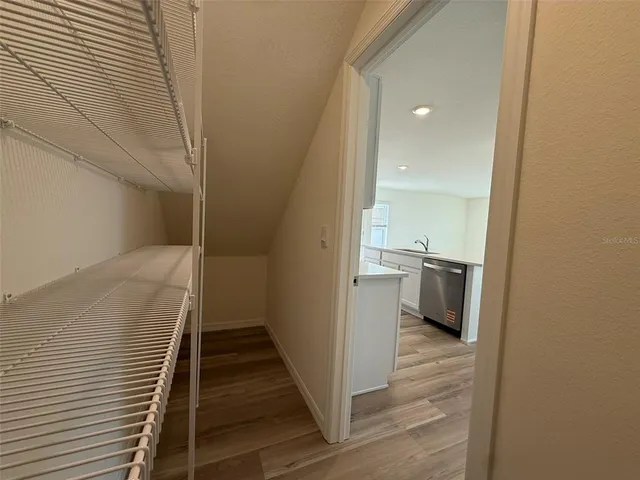 a view of a hallway with wooden floor and staircase