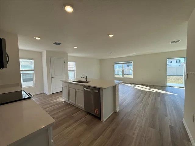 a kitchen with wooden floors and appliances