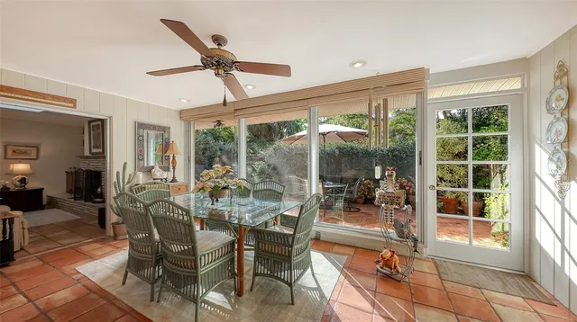a dining room with furniture large windows and a chandelier