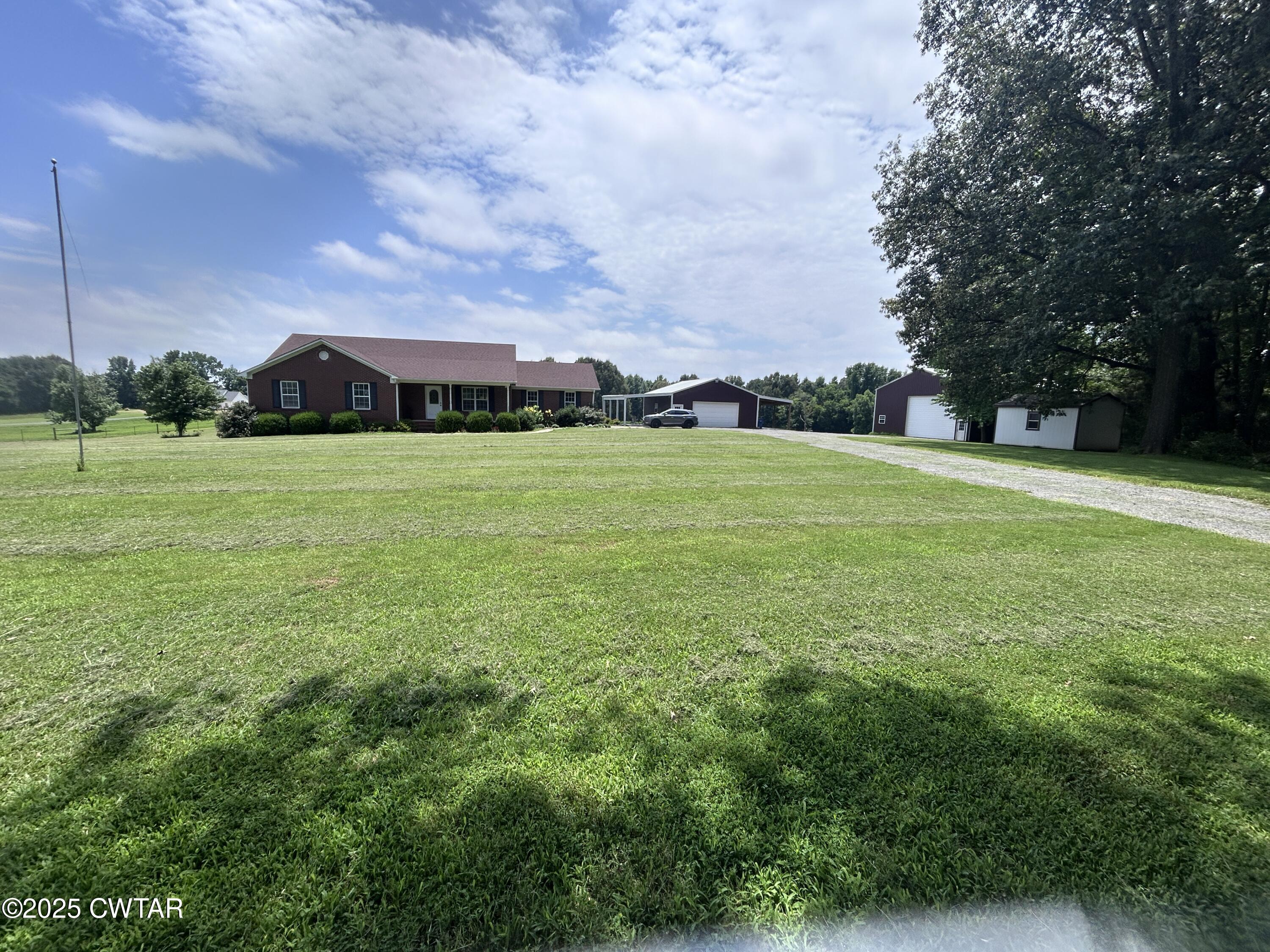 a view of a big yard with a house in the background