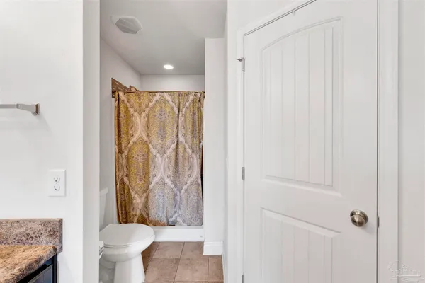 a bathroom with a granite countertop sink a toilet and shower