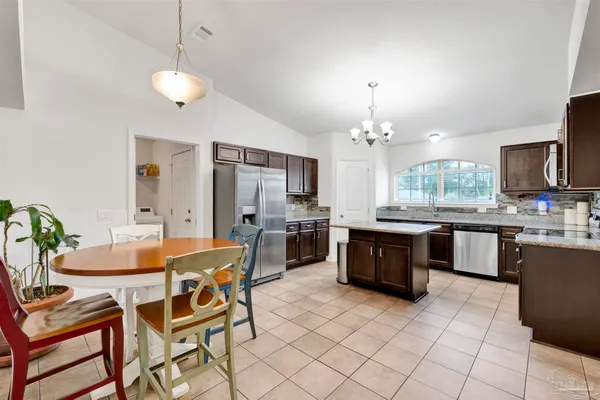 a large kitchen with a table and chairs