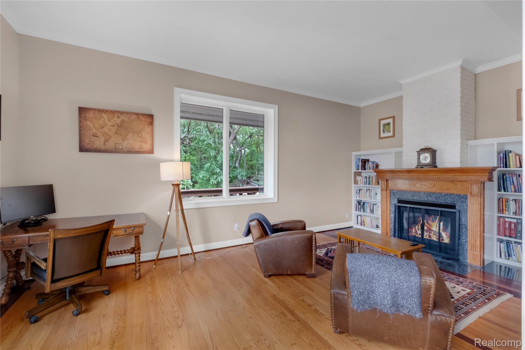 15420 Jennings Road Fenton, MI 48430 - Photo 17 of 45 Hardwood flooring, fireplace with a wood mantel, built-in shelving, white trim, and a large window