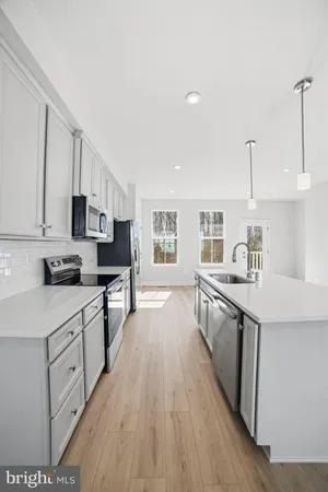 a kitchen with stainless steel appliances sink stove microwave and cabinets