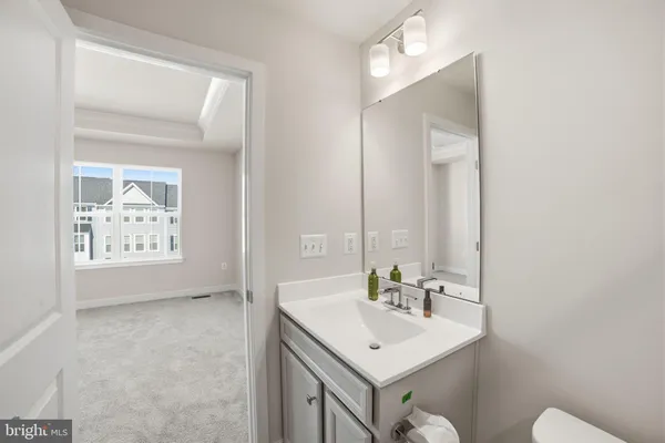 a bathroom with a sink a toilet and mirror