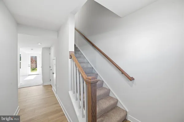 a view of a hallway with wooden floor and entryway