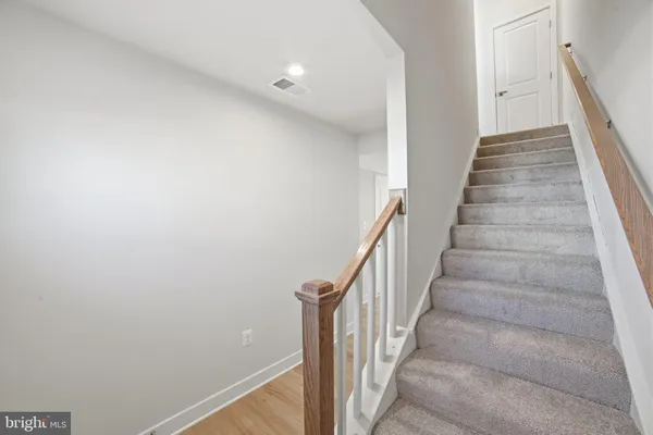 a view of staircase with wooden floor and white walls