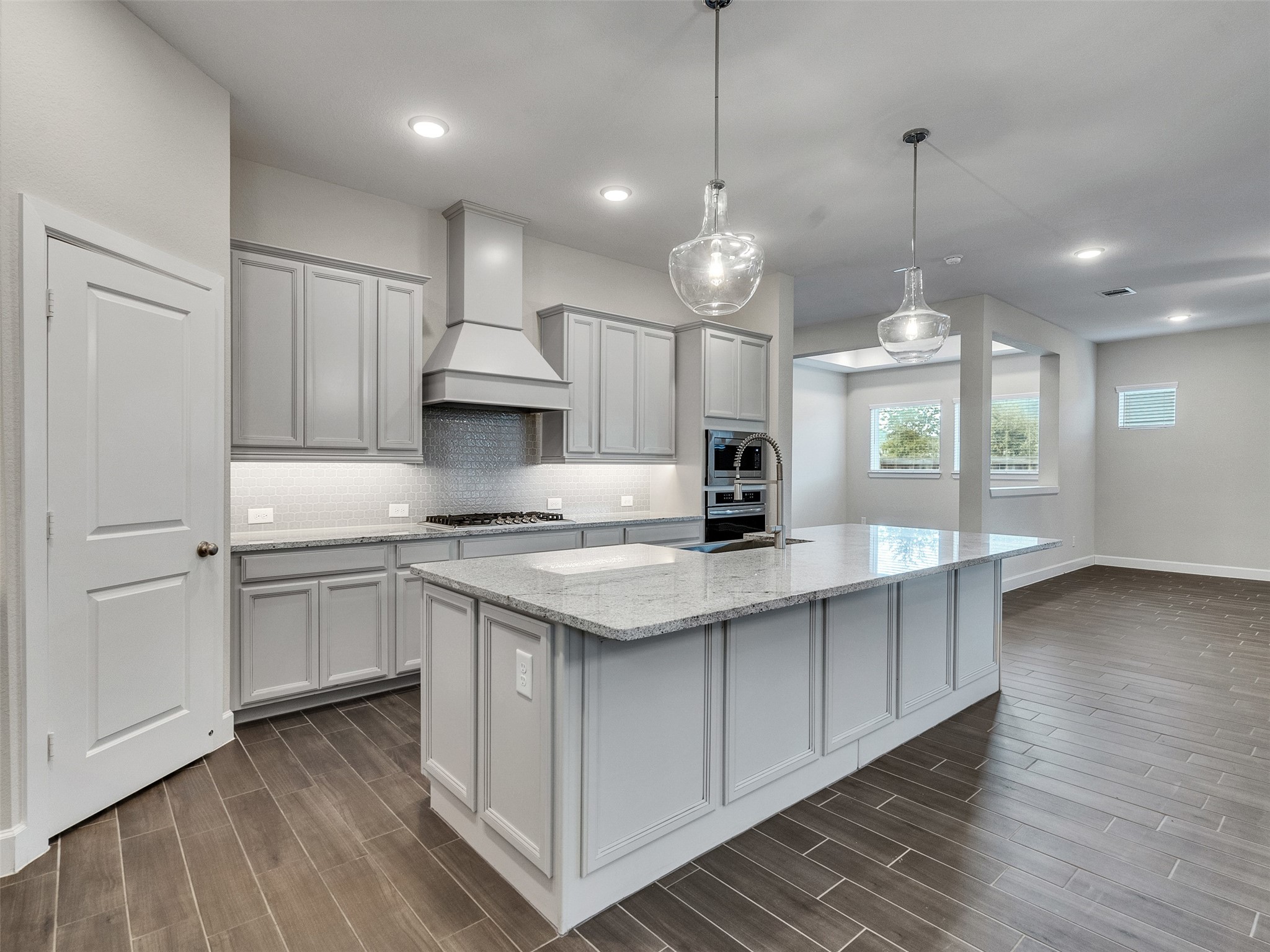 7003 Goldstrum Way Katy, TX 77493 - Photo 17 of 44 a kitchen with stainless steel appliances granite countertop a sink a stove and a wooden floors