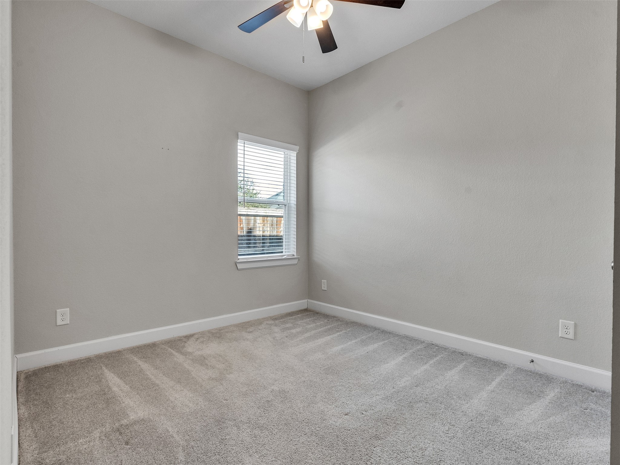7003 Goldstrum Way Katy, TX 77493 - Photo 25 of 44 an empty room with a chandelier fan and windows
