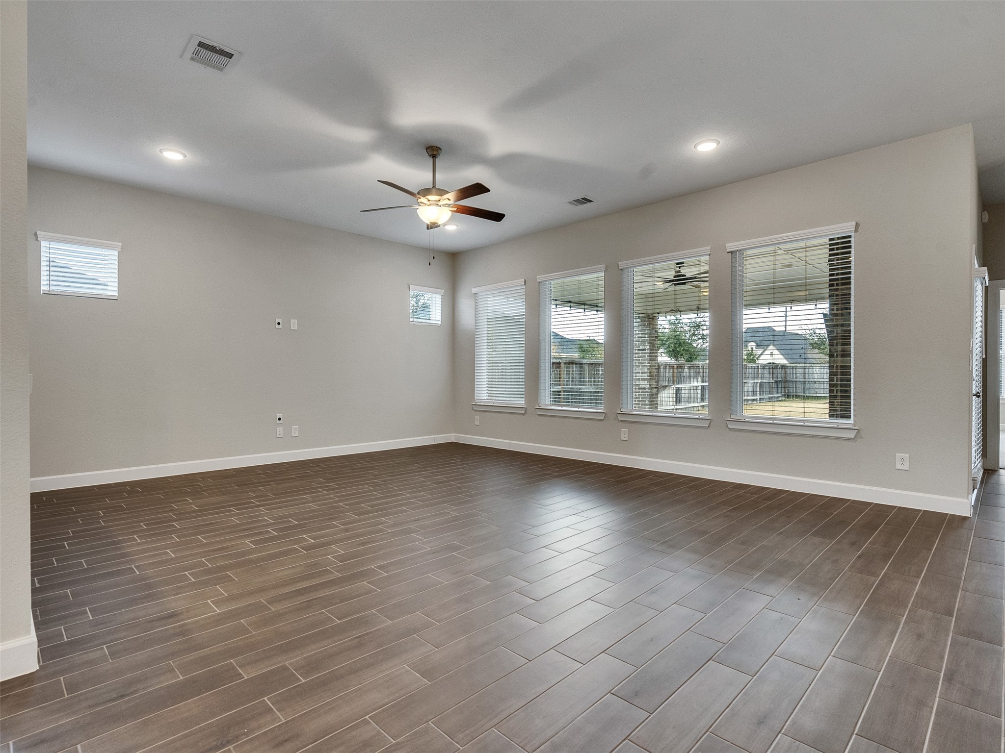 7003 Goldstrum Way Katy, TX 77493 - Photo 9 of 44 an empty room with wooden floor and windows
