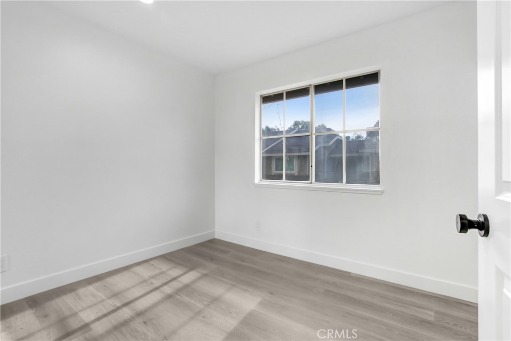 26311 Misty Glen, Unit 3 Lake Forest, CA 92630 - Photo 20 of 27 an empty room with wooden floor and windows