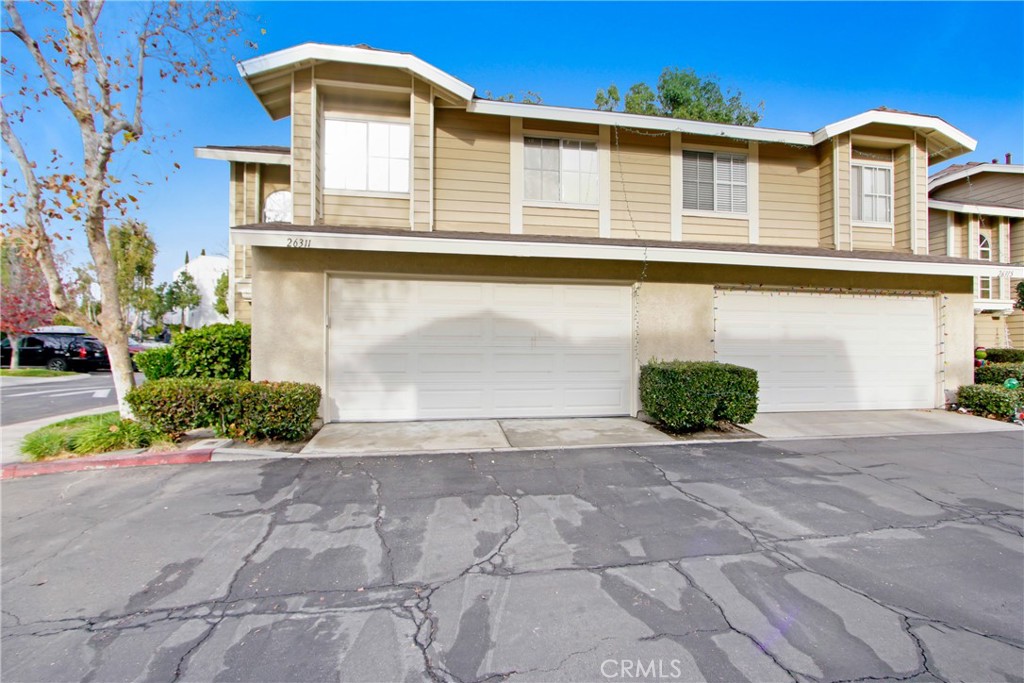 26311 Misty Glen, Unit 3 Lake Forest, CA 92630 - Photo 2 of 27 a front view of a house with a yard and potted plants
