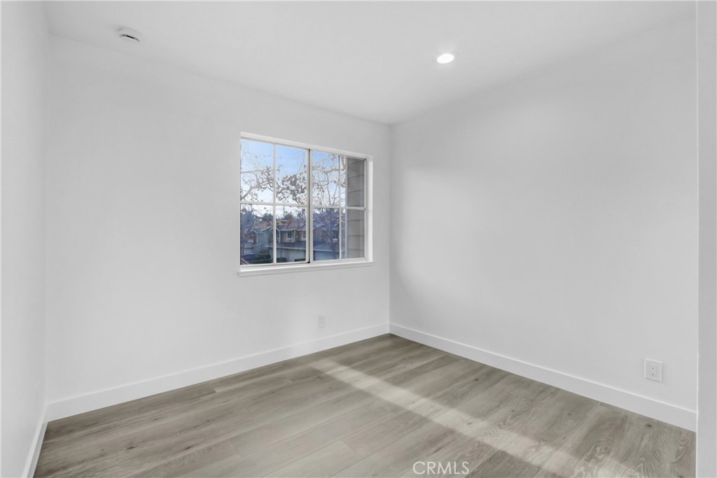 26311 Misty Glen, Unit 3 Lake Forest, CA 92630 - Photo 22 of 27 an empty room with wooden floor and windows