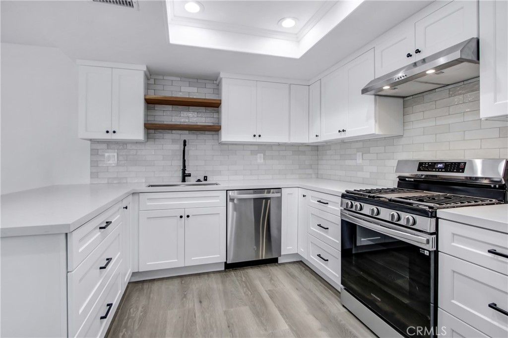 26311 Misty Glen, Unit 3 Lake Forest, CA 92630 - Photo 4 of 27 a kitchen with cabinets appliances a sink and a counter top