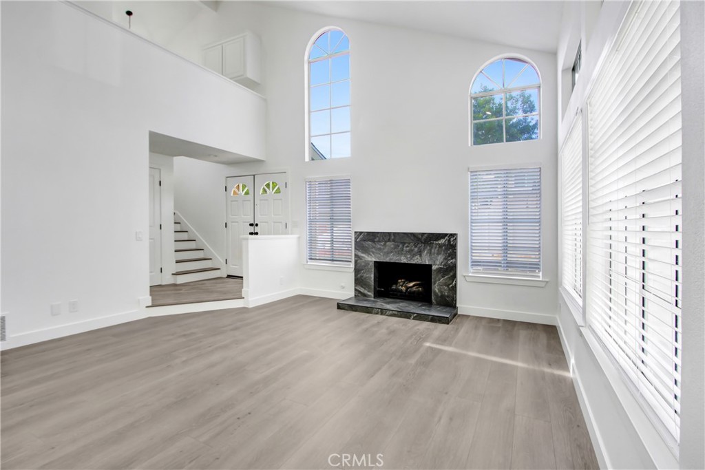 26311 Misty Glen, Unit 3 Lake Forest, CA 92630 - Photo 5 of 27 a view of an empty room with wooden floor fireplace and a window
