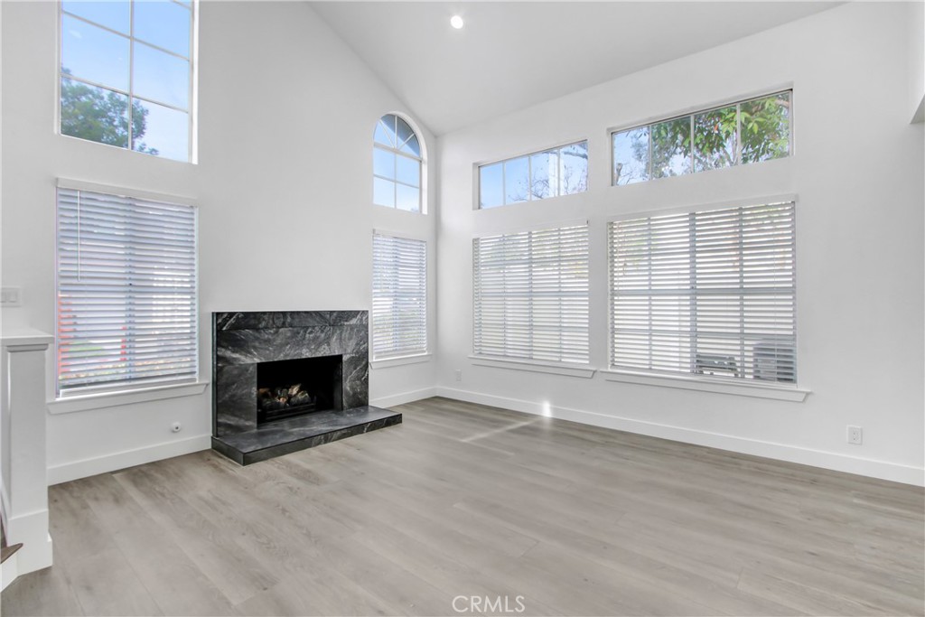 26311 Misty Glen, Unit 3 Lake Forest, CA 92630 - Photo 6 of 27 an empty room with wooden floor fireplace and windows