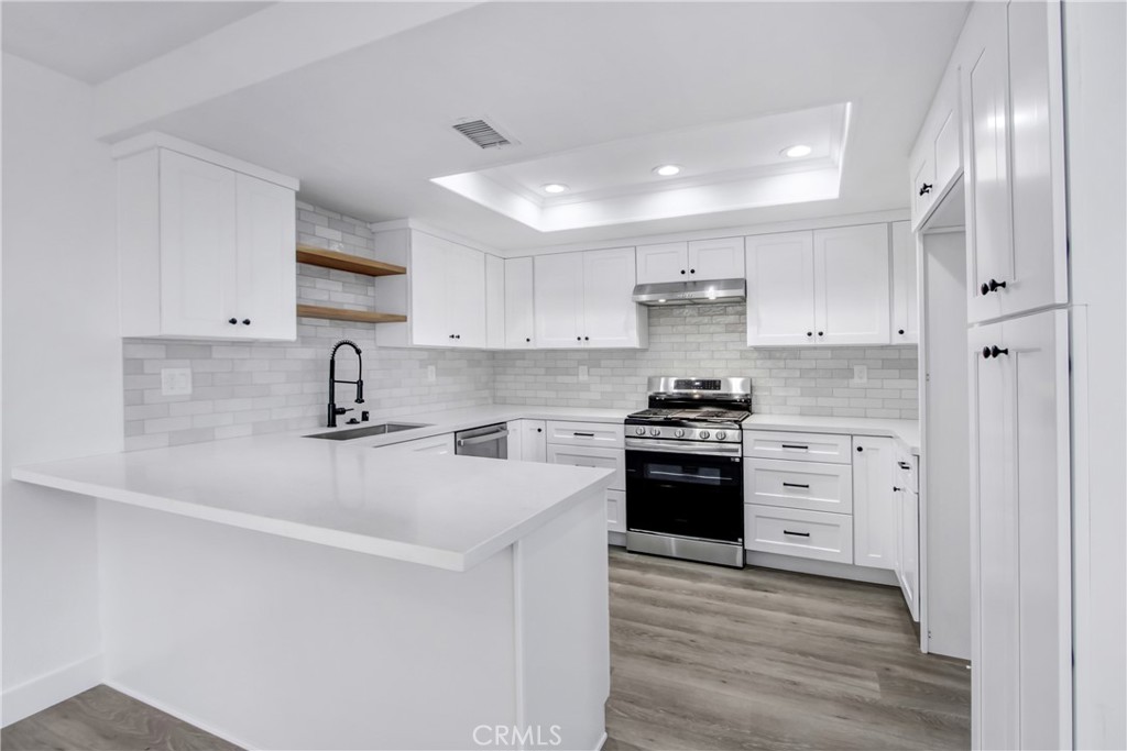 26311 Misty Glen, Unit 3 Lake Forest, CA 92630 - Photo 8 of 27 a kitchen with stainless steel appliances sink a stove and white cabinets