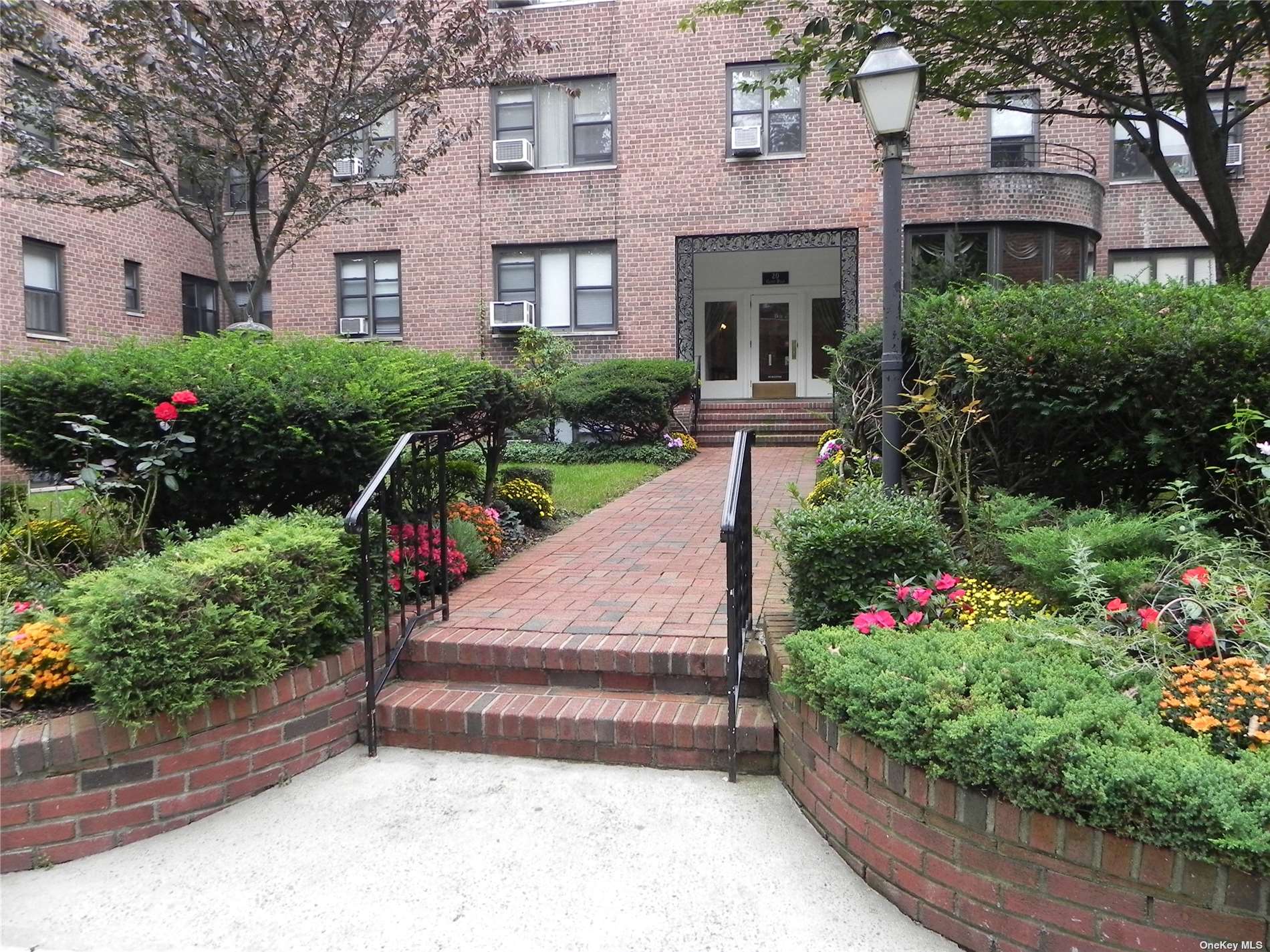 a front view of a house with a yard and potted plants