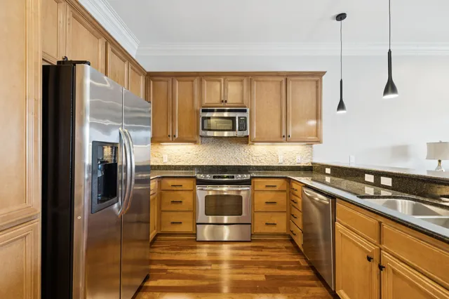 a kitchen with granite countertop a stove and a refrigerator