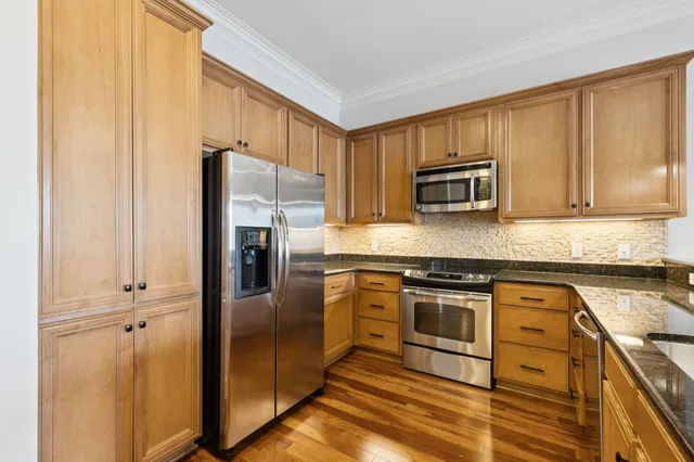 a kitchen with granite countertop a refrigerator stove and microwave