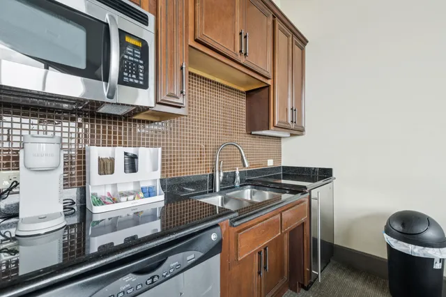 a kitchen with granite countertop a sink and a stove